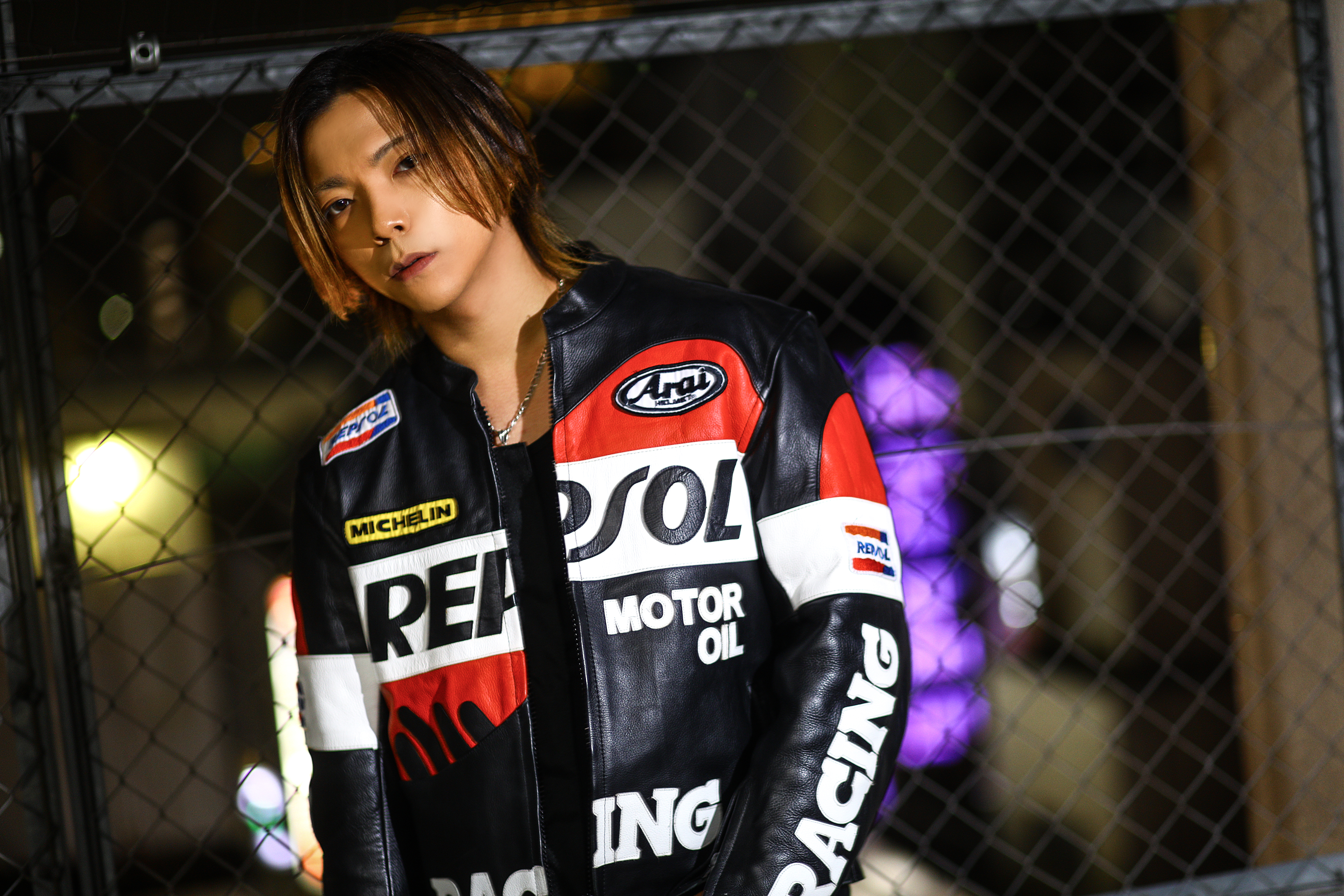 CREATE GROUP ギャラリー：レーシングジャケットのホスト、フェンス越しのポートレート